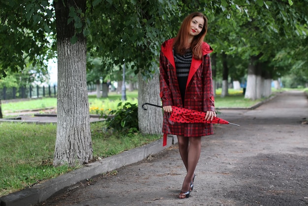 Woman with umbrella red on street tree