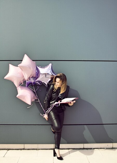 Photo woman with umbrella standing against wall