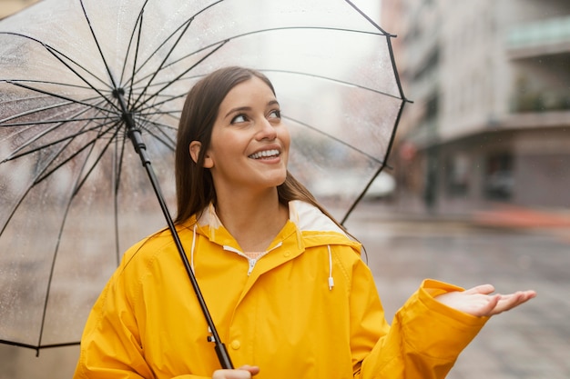 Donna con ombrello in piedi sotto la pioggia