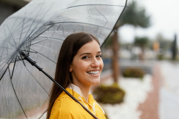 雨の中で立っている傘を持つ女性