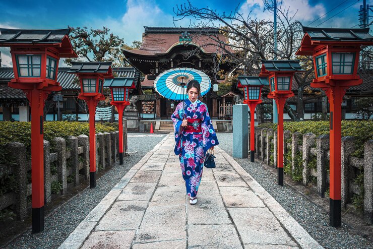 Photo 寺院の反対側の歩道を傘で歩く女性