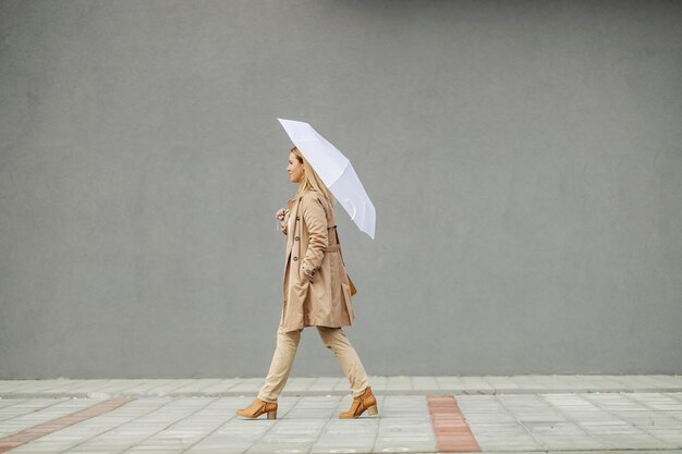 Photo a woman with umbrella walking on a pavement on city street downtown