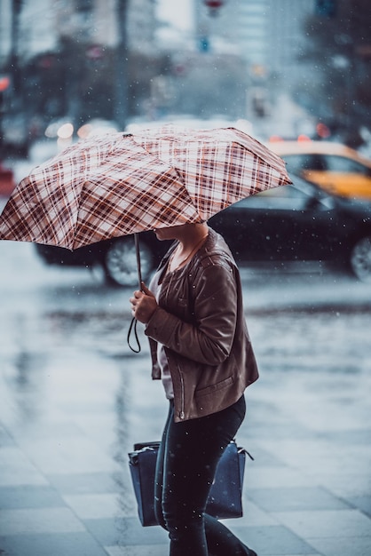 Photo woman with umbrella walking on wet street