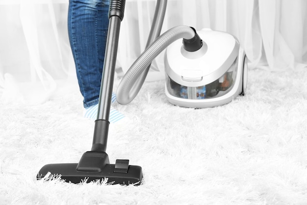 Woman with vacuum cleaner in room