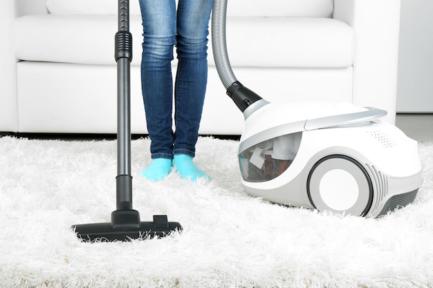 Woman with vacuum cleaner in room