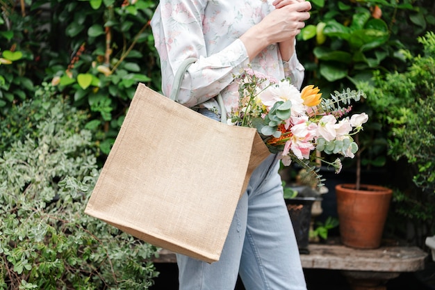 バッグの中に色々な花を持つ女性