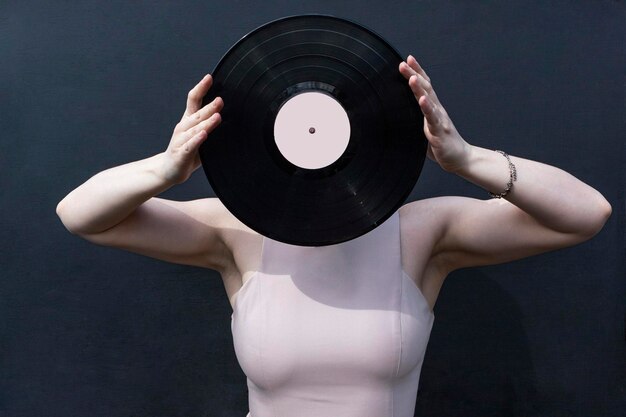 Woman with vinyl disk at her face