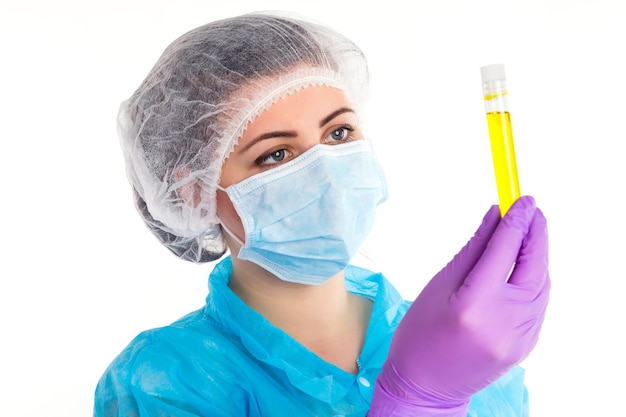 보라색 장갑을 낀 여성이 흰색 배경에 노란색 액체가 있는 튜브를 찾고 있습니다.