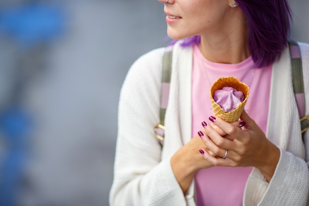 Photo woman with violet hair in white sweater holding in her hands purple ice cream