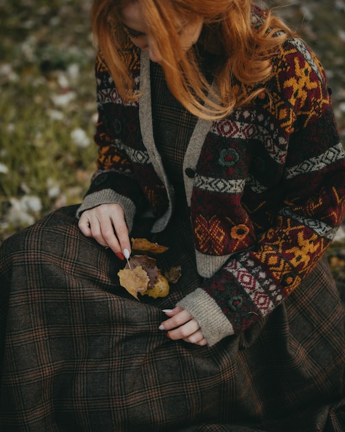 Photo woman with warm cardigan holding autumnal leaves  autumn colors