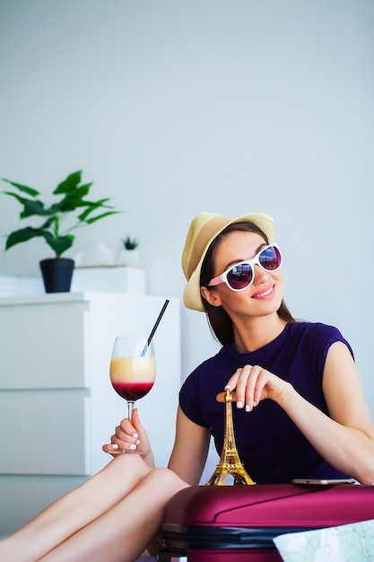 Woman with welcome cocktail in hotel room on vacation