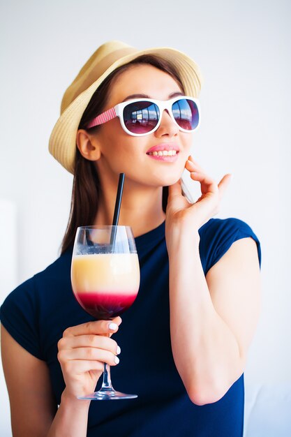 Woman with welcome cocktail in hotel room on vacation