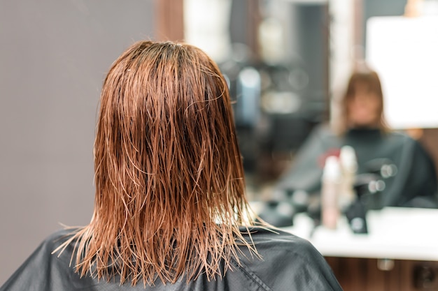 Donna con lunghi capelli castani bagnati.