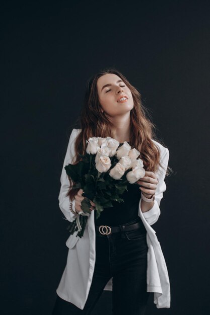 Woman with white roses on black background