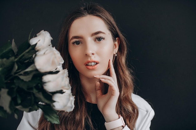 Woman with white roses on black background