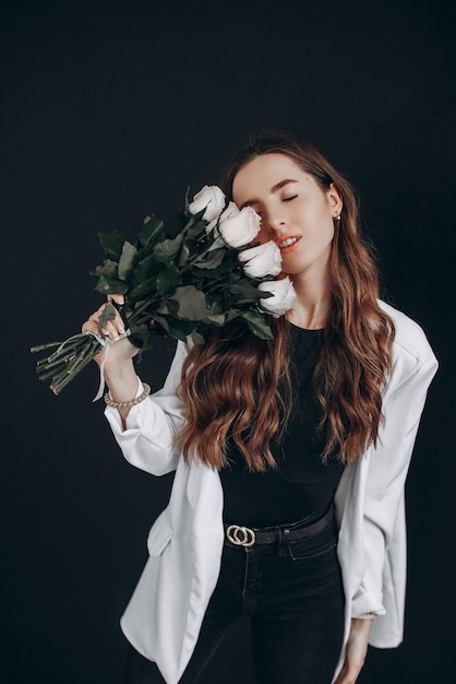 Woman with white roses on black background