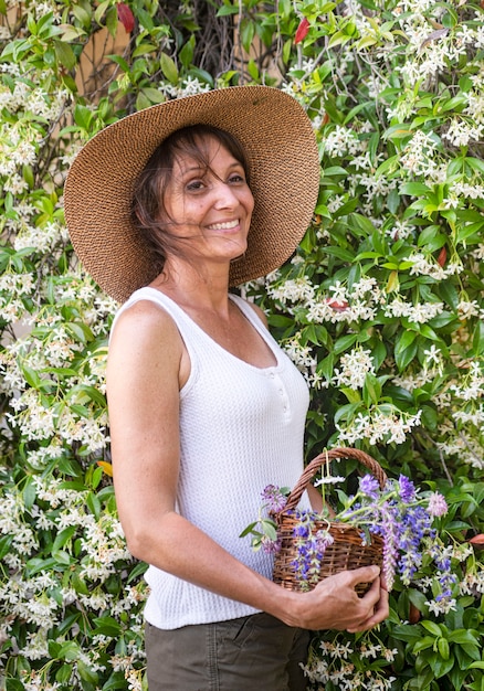 자연 요법과 식물학을 위한 바구니에 야생 꽃을 든 여자