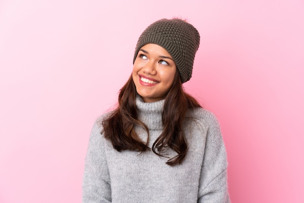 Woman with winter hat over isolated pink wall