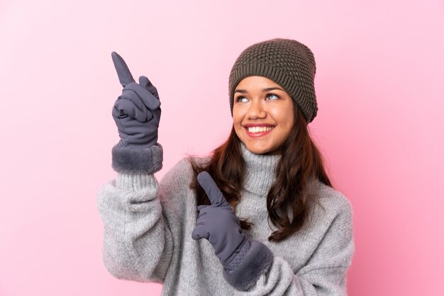 Woman with winter hat over isolated pink wall