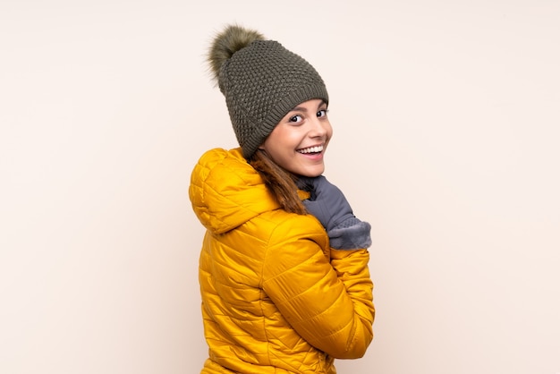 Женщина в зимней шапке над изолированной стеной