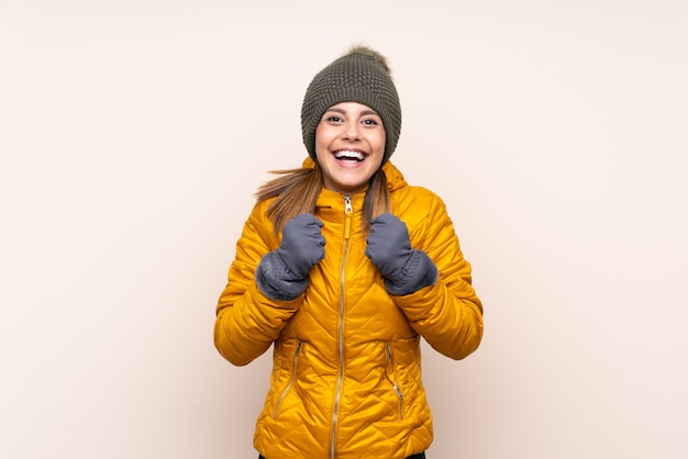 Donna con cappello invernale sul muro per celebrare una vittoria