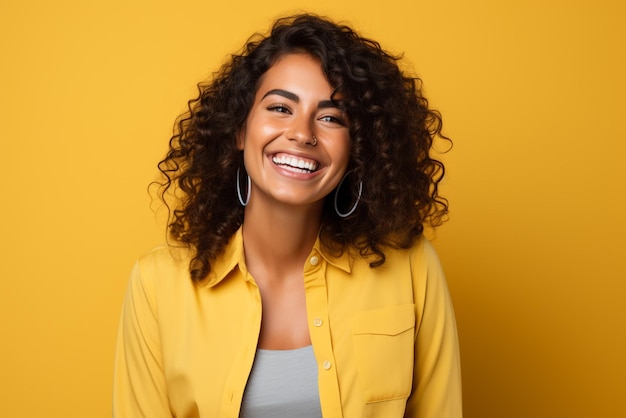 Woman with yellow blouse in a yellow background looking at the phone and smiling