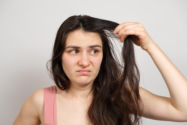 Una donna senza trucco con capelli grassi e sporchi