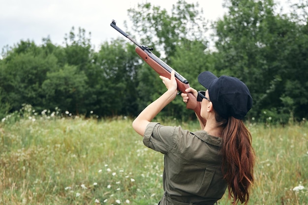 Woman woman holding a gun up hunting aiming fresh air green