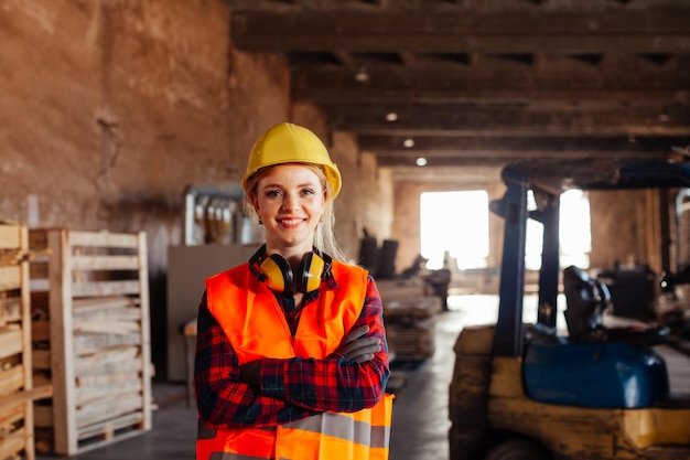 The woman woodworker chooses a board in a warehouse