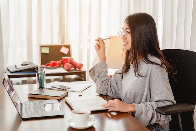 사진 집에서 일하는 여성은 집에서 곧 개선될 전염병 상황을 기다리는 동안 커피 컵을 가지고 있습니다. 코로나바이러스, covid-19, 재택근무(wfh), 사회적 거리, 격리, 감염 방지 개념.