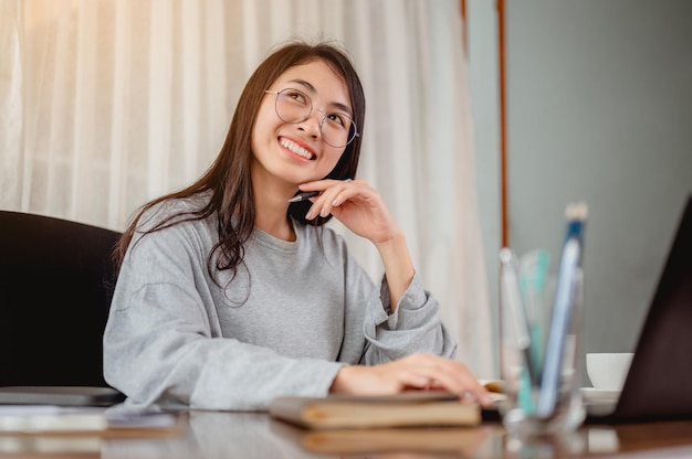 Woman work from home have a coffee cup beside wait epidemic situation to improve soon at home. Coronavirus, covid-19, Work from home (WFH), Social distancing, Quarantine, Prevent infection concept.