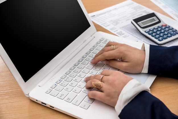 Woman work at laptop and filling tax form