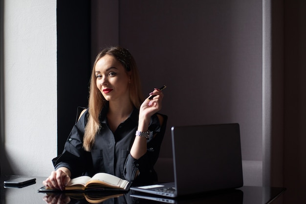 Woman at work. Portrait of positive pretty businesswoman using laptop in office.