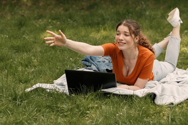 Женщина работает с ноутбуком в парке