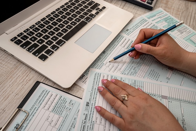 Woman work with USA tax form 1040 and calculator laptop at office. Accounting concept