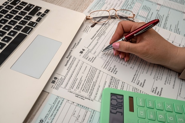 Woman work with USA tax form 1040 and calculator laptop at office. Accounting concept