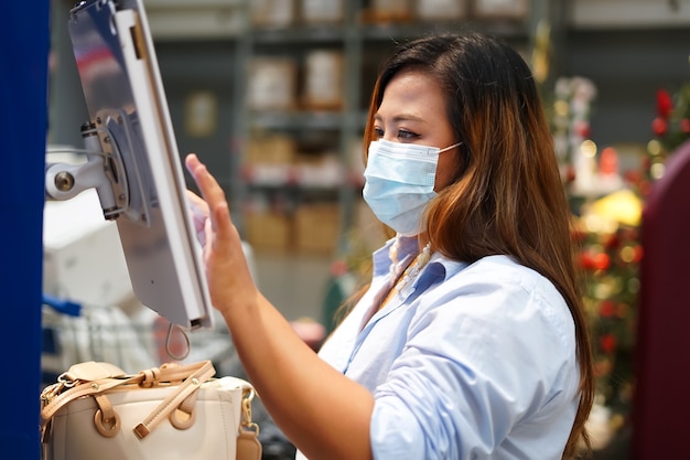 woman worker inspecting stock of products while working in large warehouse.