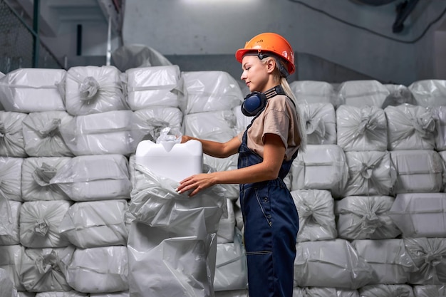 Woman worker in protective uniform working in pesticides\
production factory