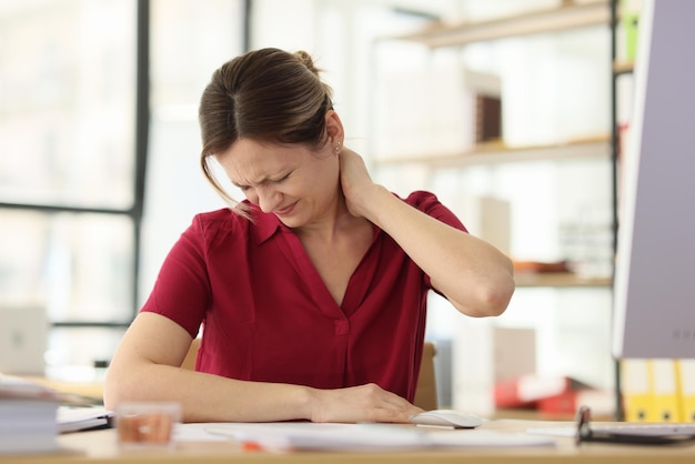 Woman worker suffers from pain in neck at office workplace