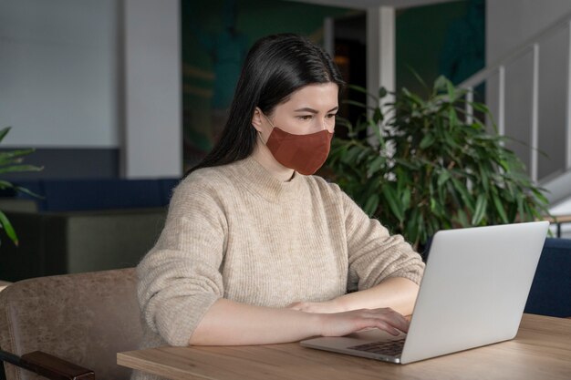 Photo woman working alone while social distancing from other coworkers