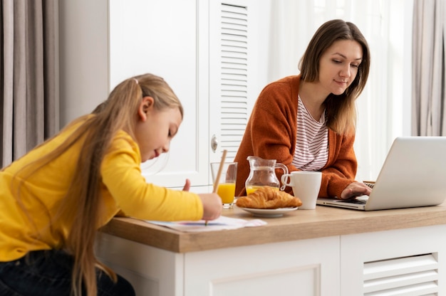 写真 ミディアムショットの女の子と在宅勤務の女性