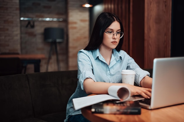 ノートパソコンでカフェで働く女性