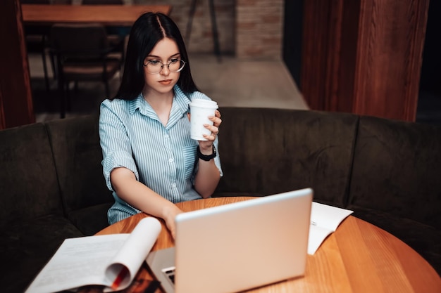 Donna che lavora al bar con il laptop