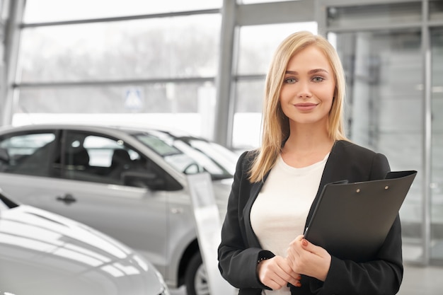 Donna che lavora nel concessionario auto come manager.