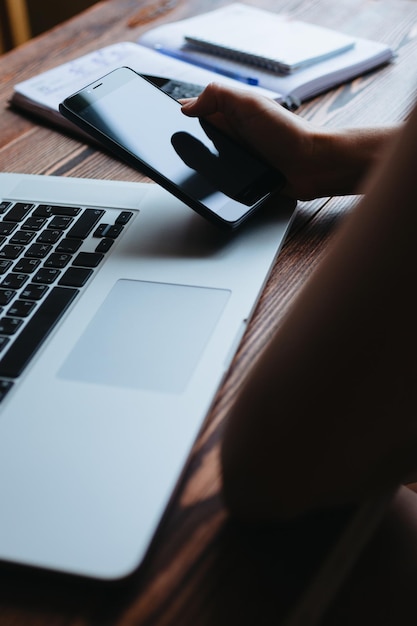 Woman working on computer and looking at the phone