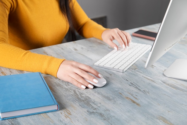 Woman working computer and notebook with phone on table