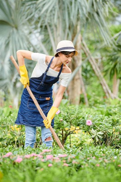Женщина, работающая в цветочном саду