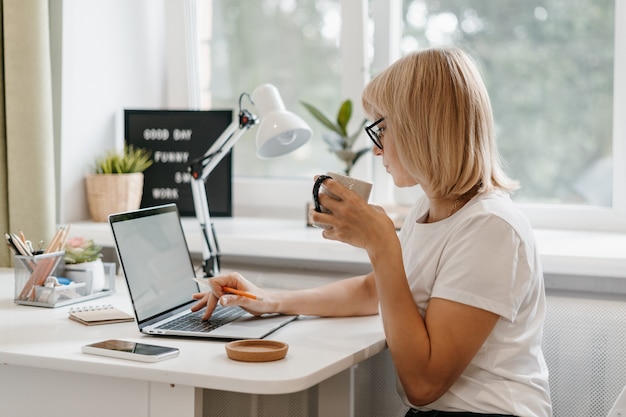 Donna che lavora da casa sul computer portatile