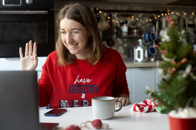 Woman working from home winter holidays wearing christmas pajamas