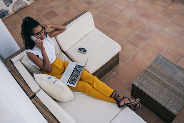 Woman working from home at the yard on her computer